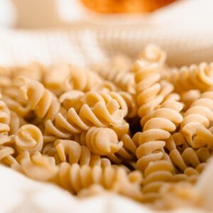 High-quality close-up of uncooked fusilli pasta in a basket, perfect for food photography.