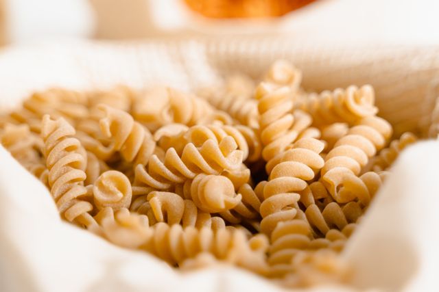 High-quality close-up of uncooked fusilli pasta in a basket, perfect for food photography.